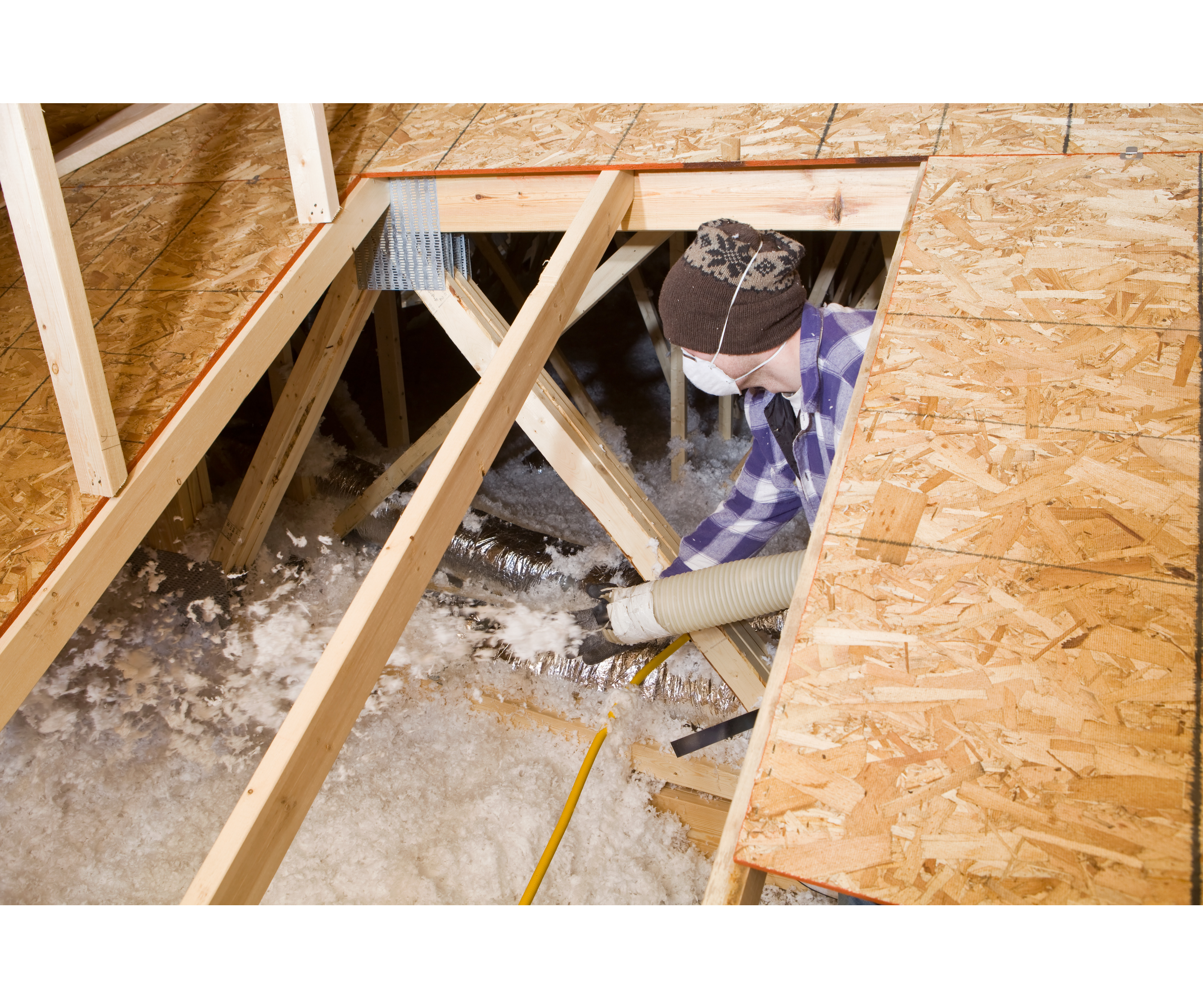 Worker installing insulation in attic space, improving energy efficiency and indoor air quality for better HVAC performance and reduced energy bills.